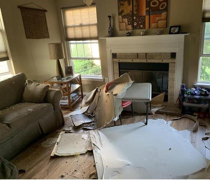 water damaged living room. Parts of waterdamaged ceiling fallen on floor
