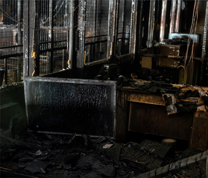 a fire damageed office with soot covering the walls and desks