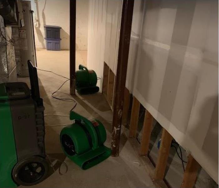 water damaged room; flood cuts in wall, SERVPRO restoration equipment being used