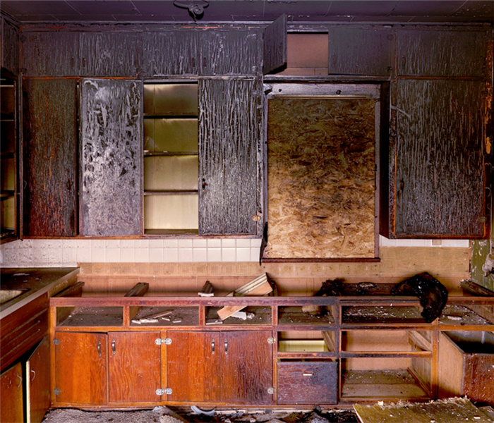 a fire damaged kitchen with soot covering the cabinets